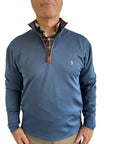 Man wearing a blue pullover with a visible brand logo against a plain background