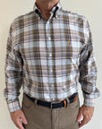 Man wearing a plaid shirt with a visible brand logo of a labrador retriever