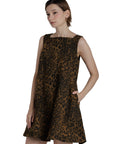 Woman wearing a leopard print dress against a plain background