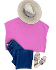 flatlay of women's pink sweater, hat, jeans, and sandles