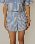 Person wearing a blue and white striped outfit with a plain background