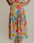 A woman wearing a yellow multicolor skirt that looks watercolors.