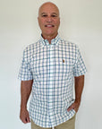 Man wearing a checkered shirt with a logo on a white background