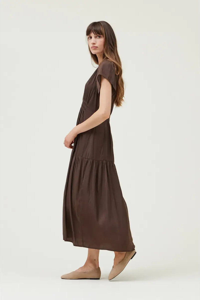 Woman wearing a brown dress on a white background