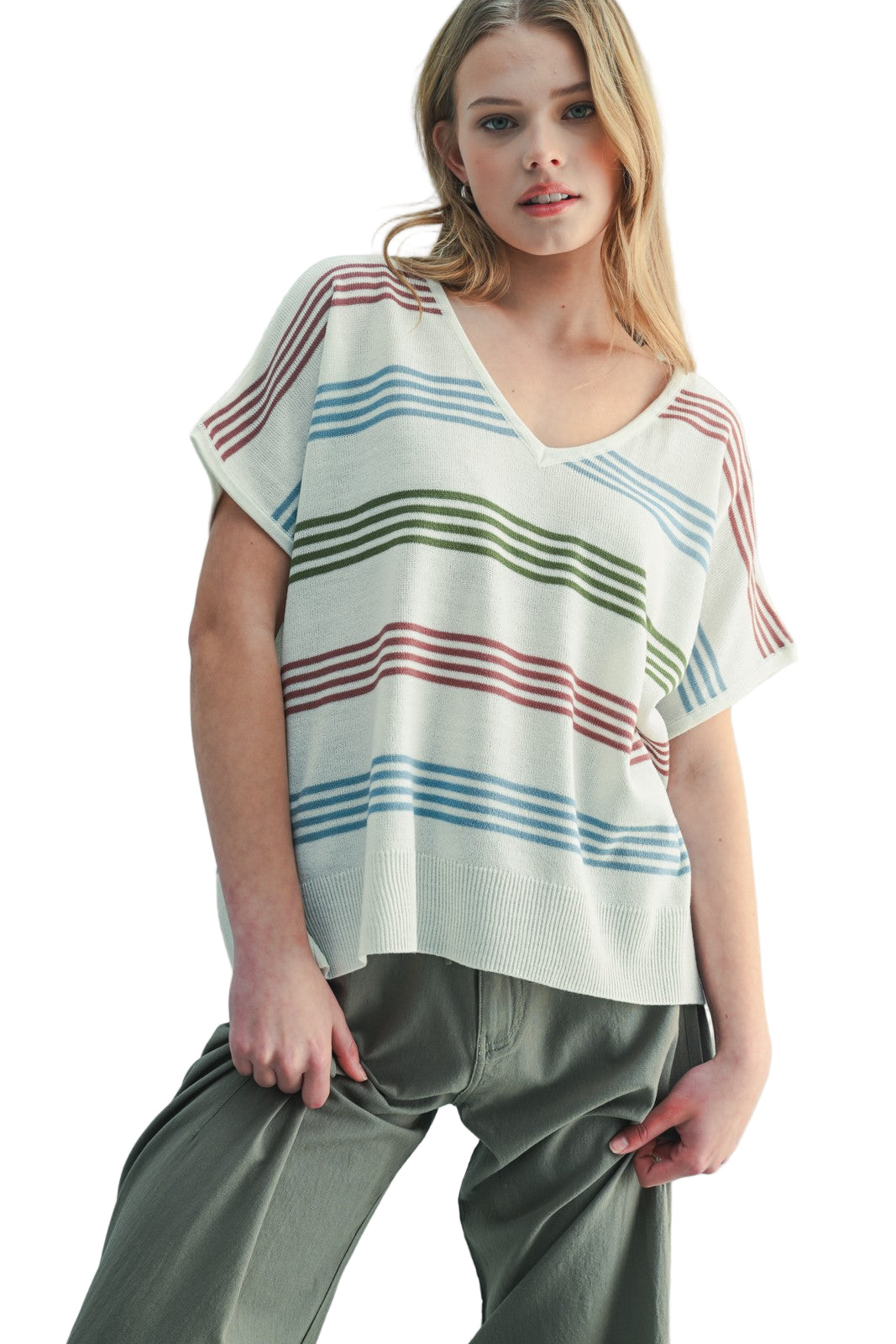 Woman wearing a striped top and pants against a light background