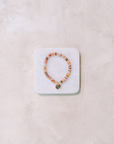 Beaded bracelet on a white stone display block against a light background