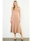 Woman wearing a beige pleated dress on a white background
