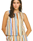 Woman wearing a sleeveless striped top and pants on a beige background