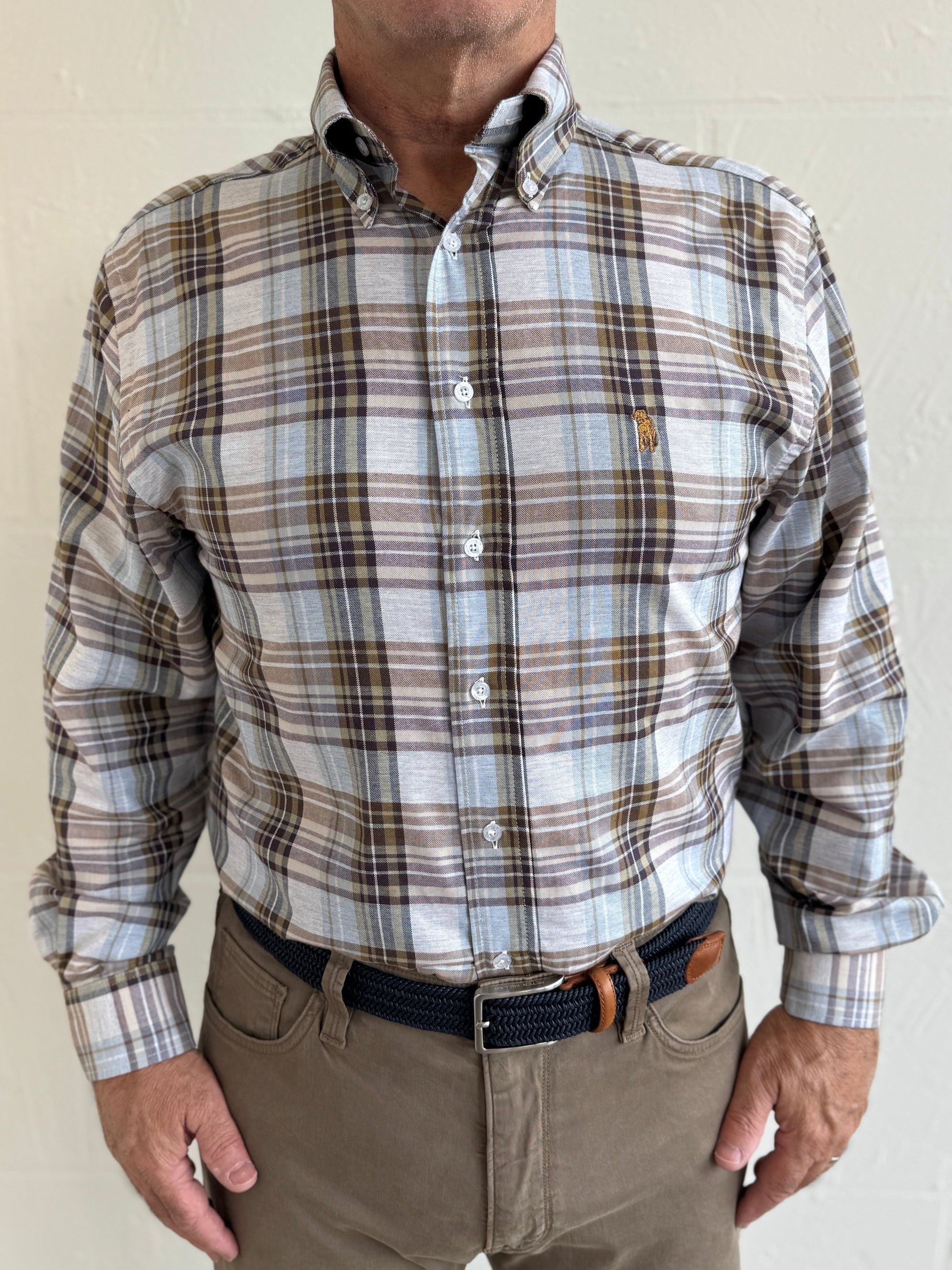 Man wearing a plaid shirt with a visible brand logo of a labrador retriever 