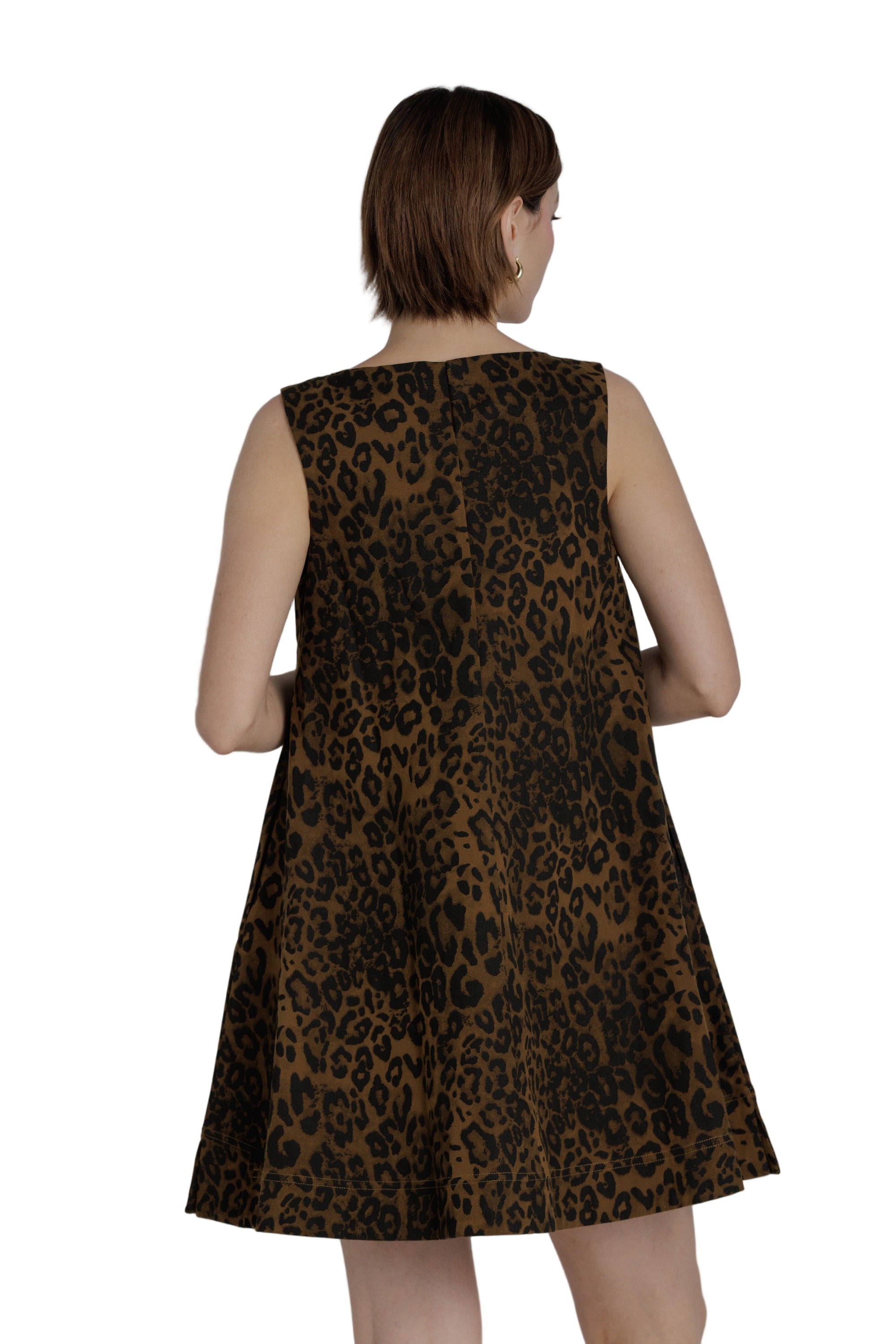 Woman wearing a leopard print dress against a plain background