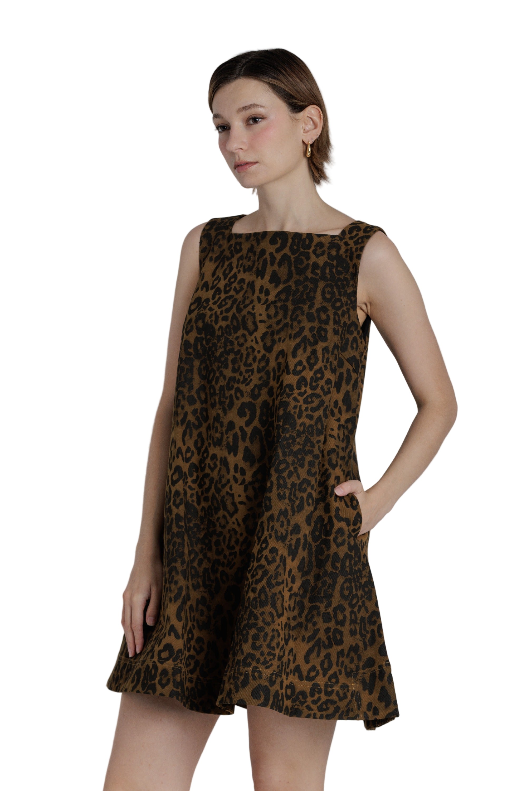 Woman wearing a leopard print dress against a plain background