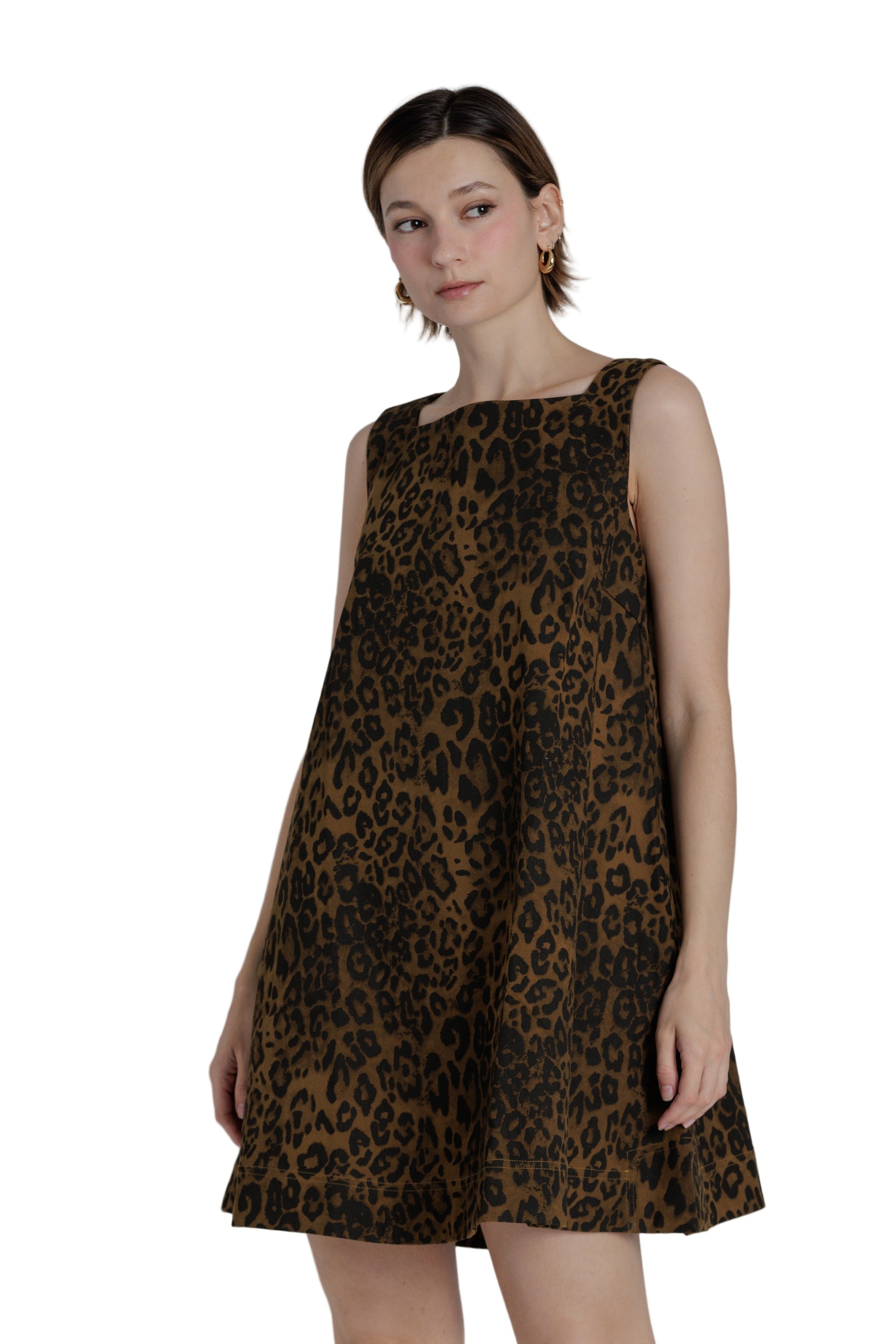 Woman wearing a leopard print dress against a plain background