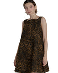 Woman wearing a leopard print dress against a plain background