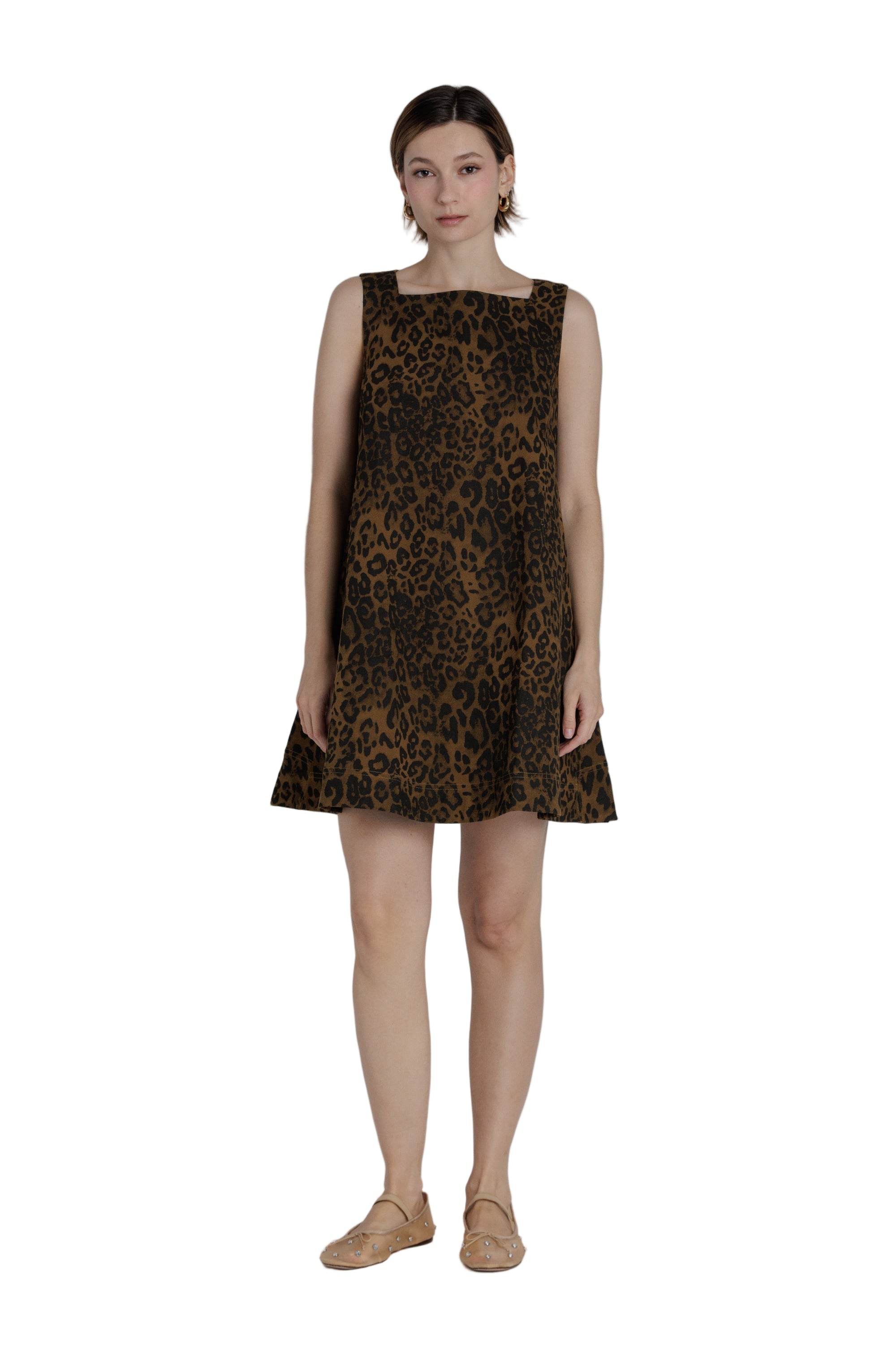 Woman wearing a leopard print dress on a plain background