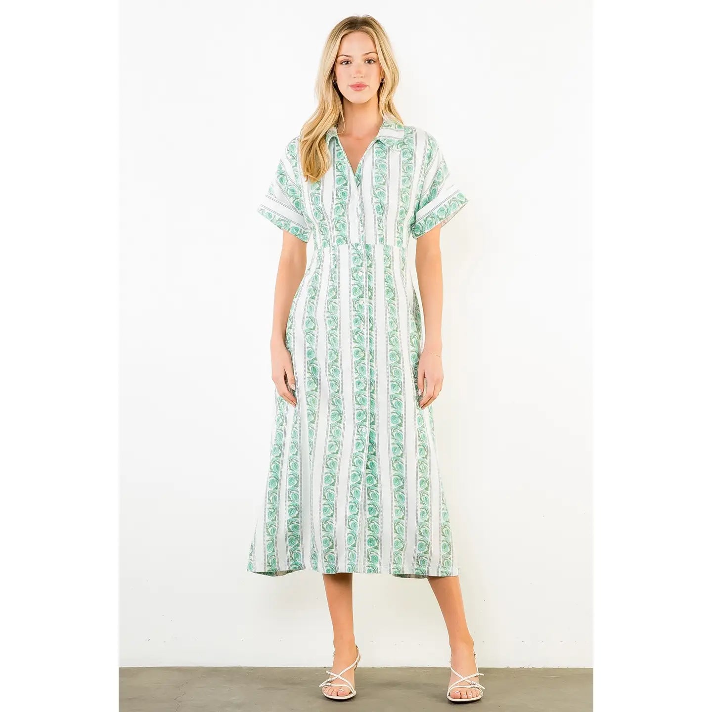 Woman wearing a green and white patterned dress on a white background