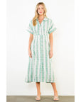 Woman wearing a green and white patterned dress on a white background
