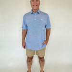 Man wearing a blue striped polo shirt and beige shorts against a white background