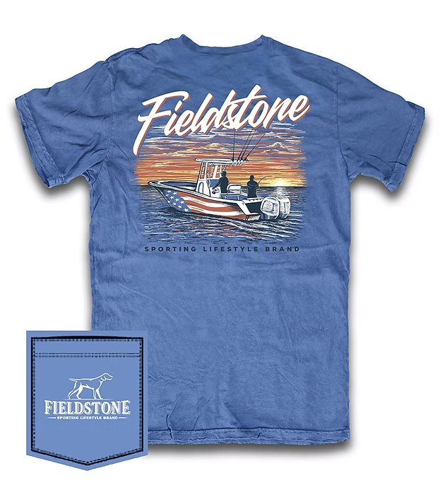 Blue t-shirt with 'Fieldstone' branding and an American Flag wrapped center console boat graphic design on a white background