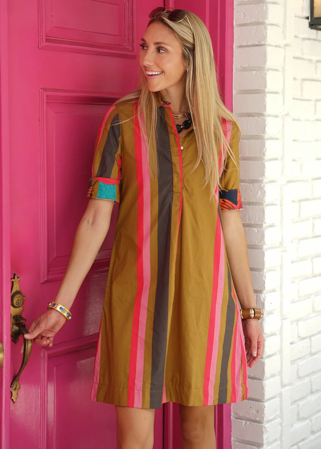 A model wearing the Charlize Mini Dress in mustard stripe by Just Darviny, from Chatsworth Boutique in Fairhope, Alabama.