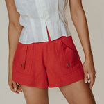 A woman wearing bright red high waist shorts.
