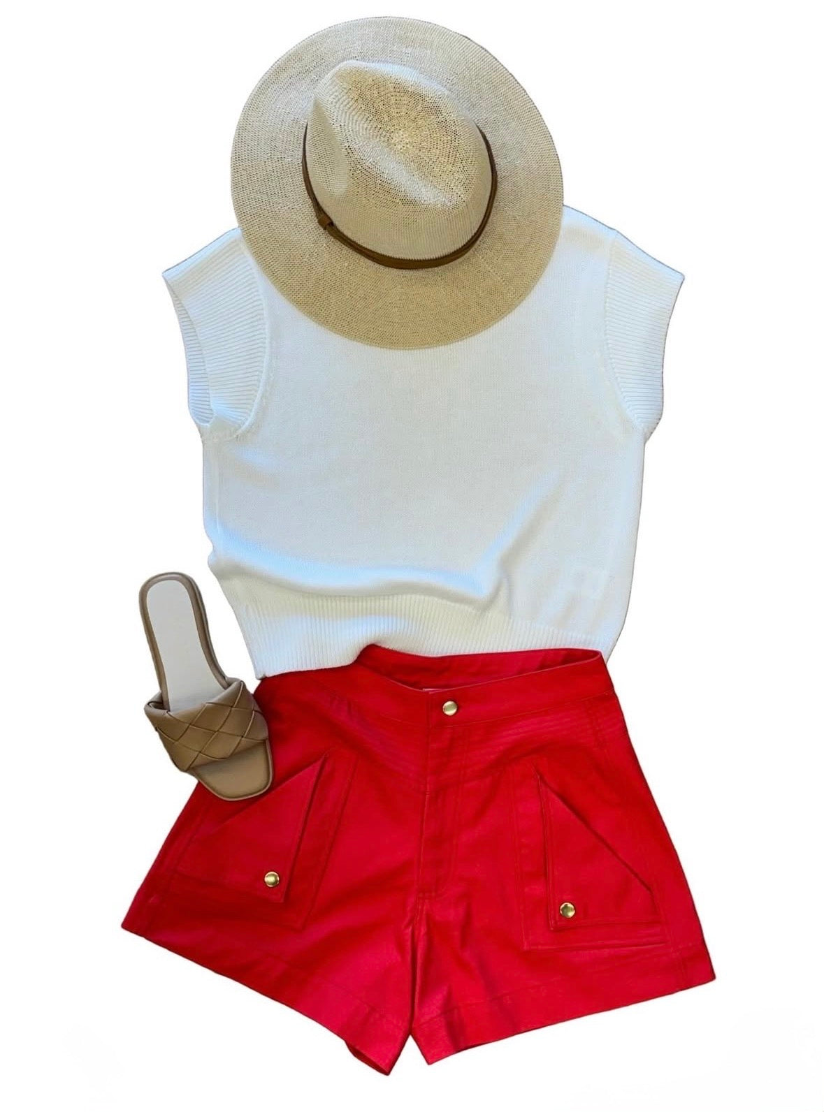An outfit consisting of red shorts, a white blouse, tan sandals and a tan sun hat.