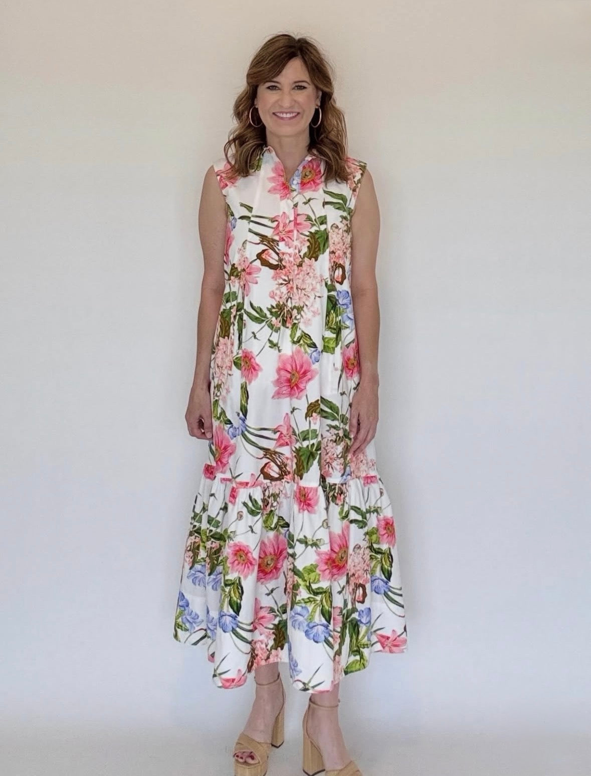 A woman wearing a sleveless maxi shirtdress with a collar and a ruffle at the bottom.