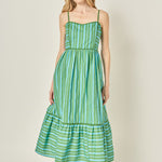 Woman wearing a green striped dress against a plain background