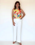 A woman wearing a round neck, sleeveless blouse in a yellow watercolor print.