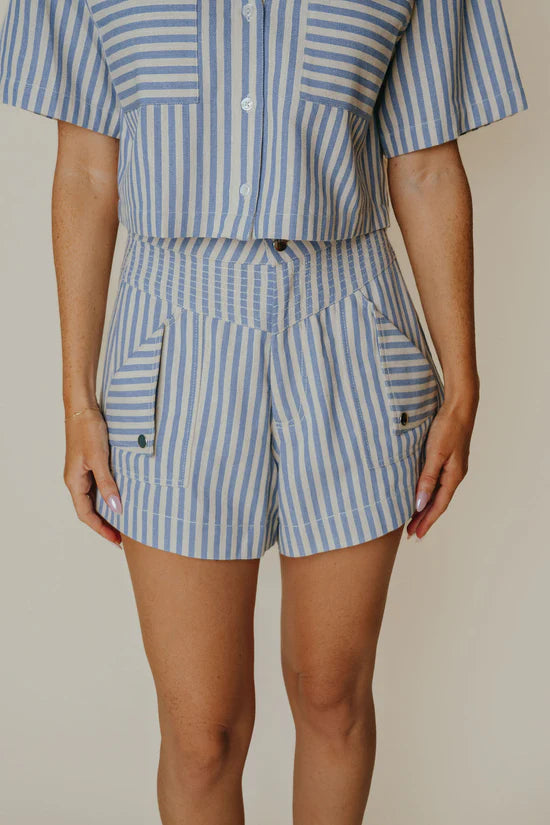 Person wearing a blue and white striped outfit with a plain background