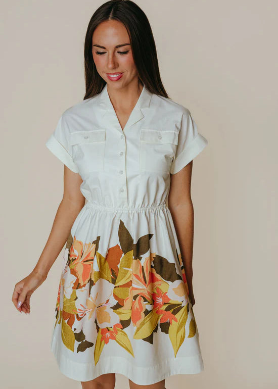 Woman wearing a white dress with floral pattern on a beige background