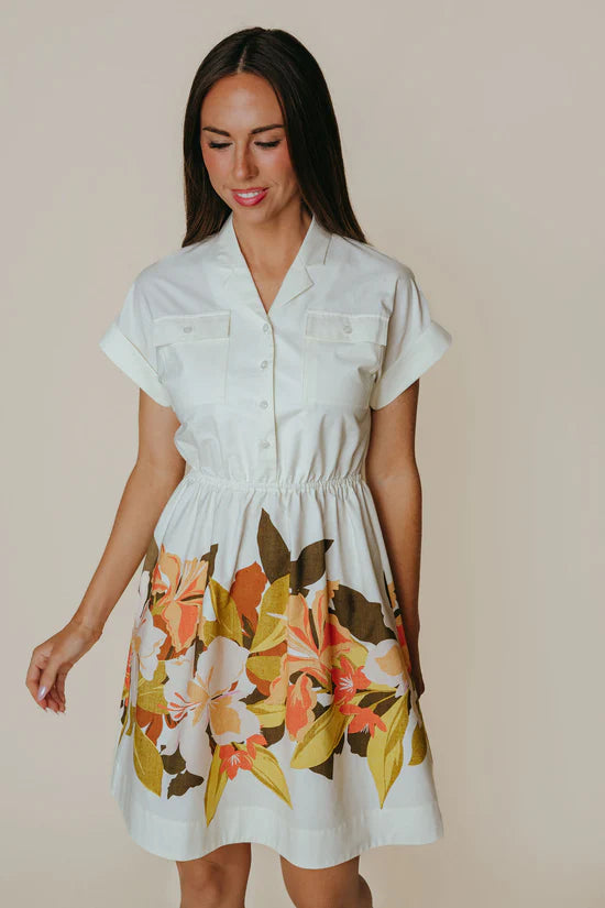 Woman wearing a white dress with floral pattern on a beige background