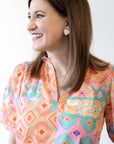 photo of chatsworth owner, Leah, looking off to the side wearing a bright orange and pink top