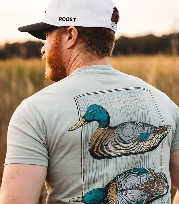 Man wearing a t-shirt with a mallard duck design outdoors