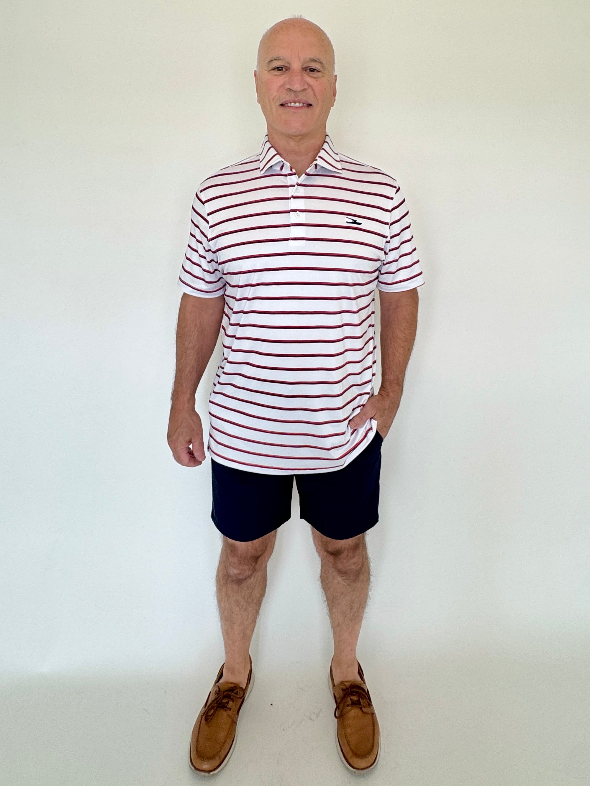 Man wearing a striped polo shirt and shorts against a white background