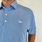 Man wearing a blue striped polo shirt with a logo on a plain background