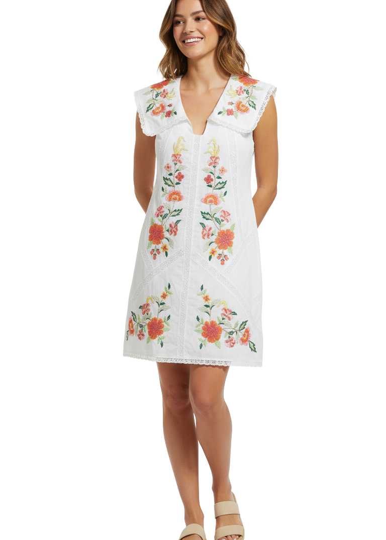 Woman wearing a white dress with floral embroidery on a white background