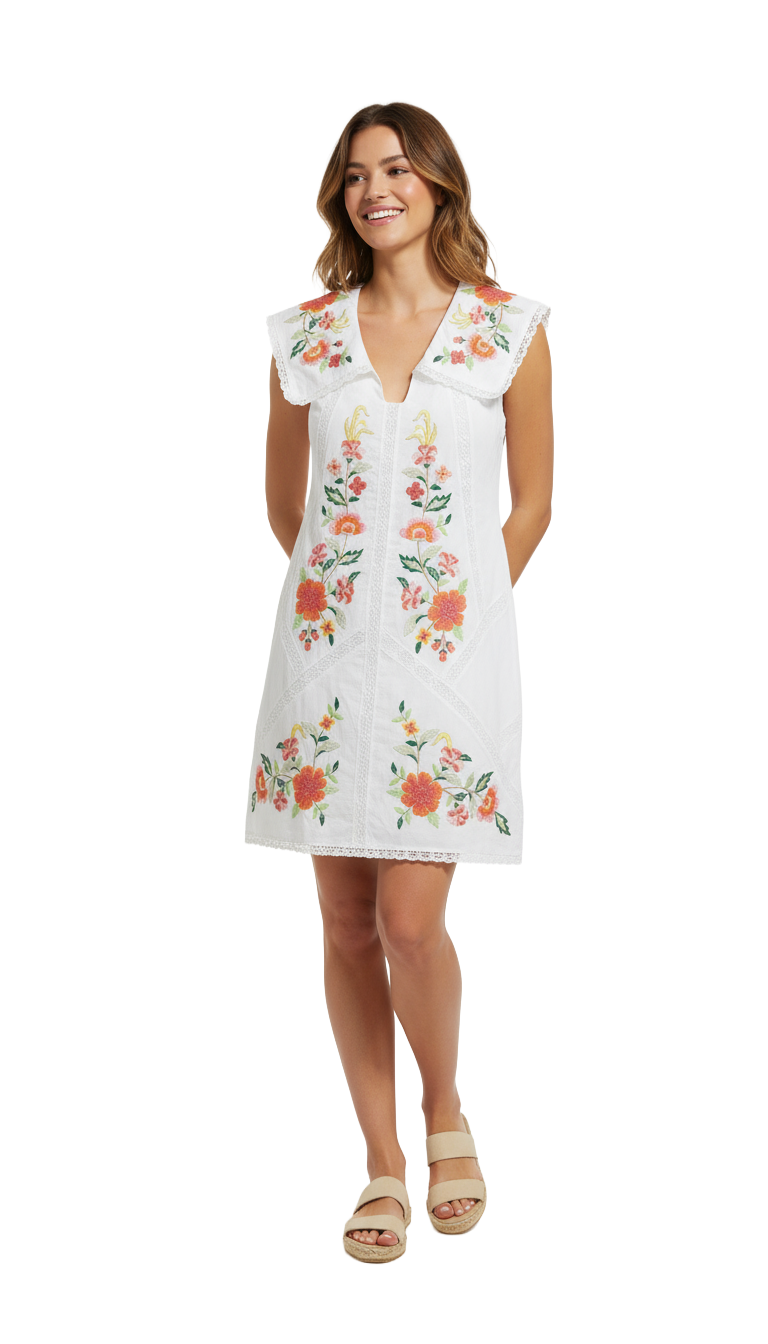 Woman wearing a white dress with floral embroidery on a white background