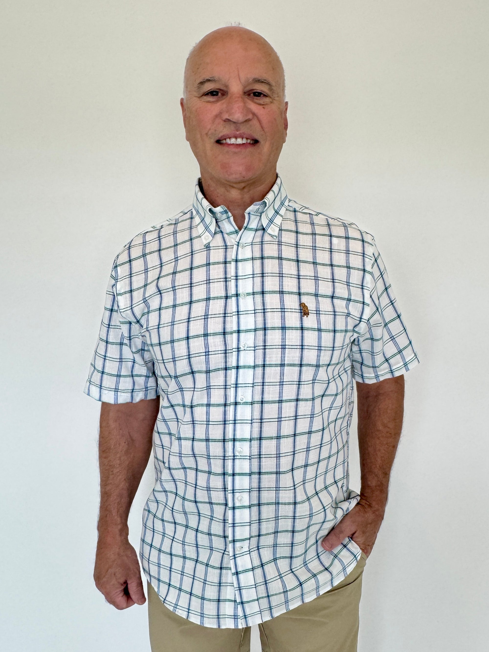 Man wearing a checkered shirt with a logo on a white background