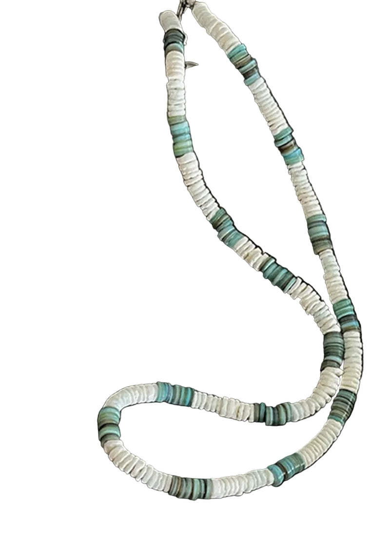 Necklace with green and white beads on a dark surface