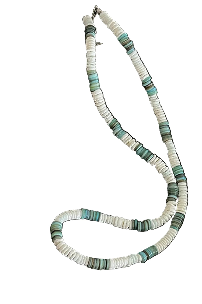 Necklace with green and white beads on a dark surface