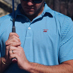 A man wearing the Albatross Performance Golf Polo in Aruba/Regatta Stripe by Bald Head Blues, front view, from Chatsworth Boutique in Fairhope, Alabama.