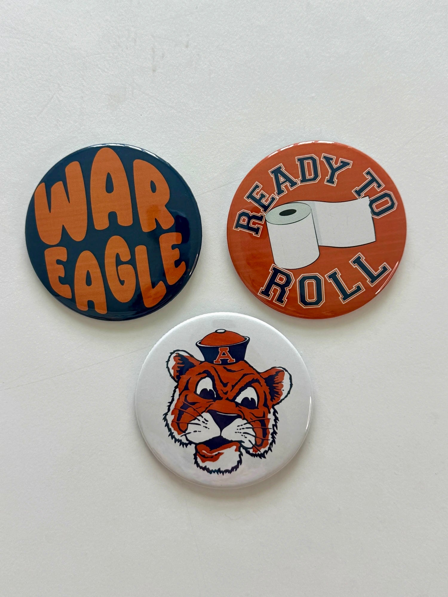 Auburn game day pin-back button set featuring War Eagle, Ready to Roll, and Tiger Mascot designs, from Chatsworth Boutique in Fairhope, Alabama.