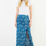 A model wearing the Button Detail Fish Skirt by THML, a blue midi skirt with a white fish print and side slit button detail, from Chatsworth Boutique in Fairhope, Alabama.