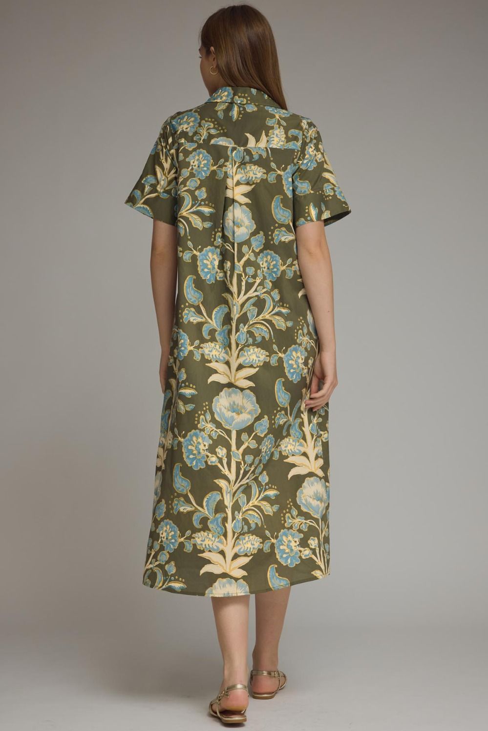 A model posing in the Contrast Trim Shirtdress Midi by Entro, an olive floral midi dress with side pockets, from Chatsworth Boutique in Fairhope, Alabama.