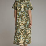 A model posing in the Contrast Trim Shirtdress Midi by Entro, an olive floral midi dress with side pockets, from Chatsworth Boutique in Fairhope, Alabama.
