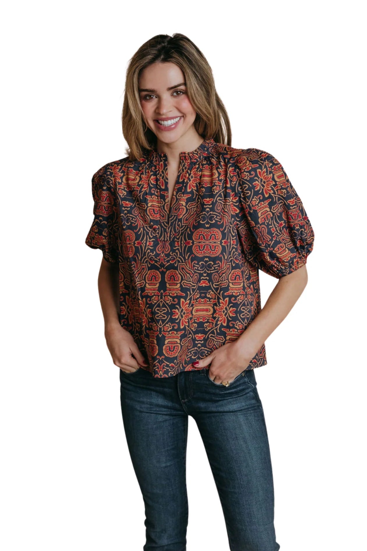 Woman wearing a patterned blouse and jeans on a white background