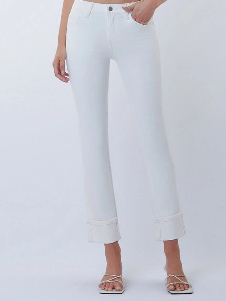 Woman wearing a white crop top and white pants on a plain background