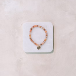 Beaded bracelet on a white stone display block against a light  background