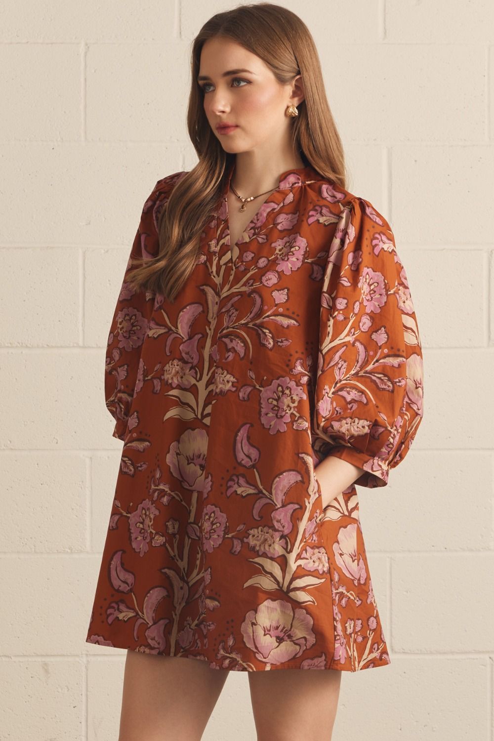 Front view of the Floral V-Neck Mini in rust by Entro, showing the 3/4 puff sleeves and V-neck detail, from Chatsworth Boutique.