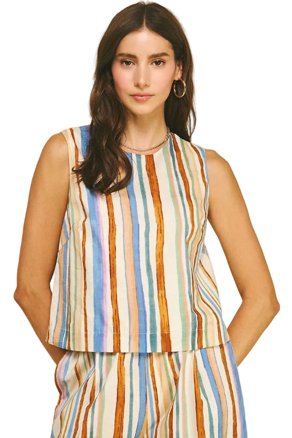 Woman wearing a sleeveless striped top and pants on a beige background